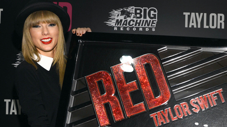 Taylor Swift posing with "Red" award