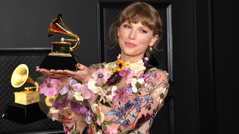 Taylor Swift holding up Grammy