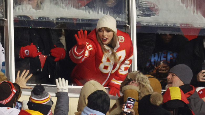 Taylor Swift wearing a Travis Kelce puffer jacket