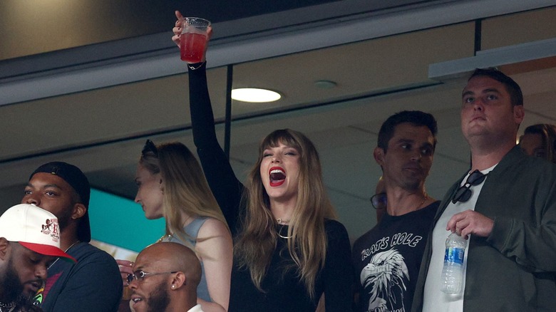 Taylor Swift cheering, raising cup