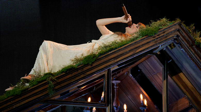 Taylor Swift singing lying on grass platform