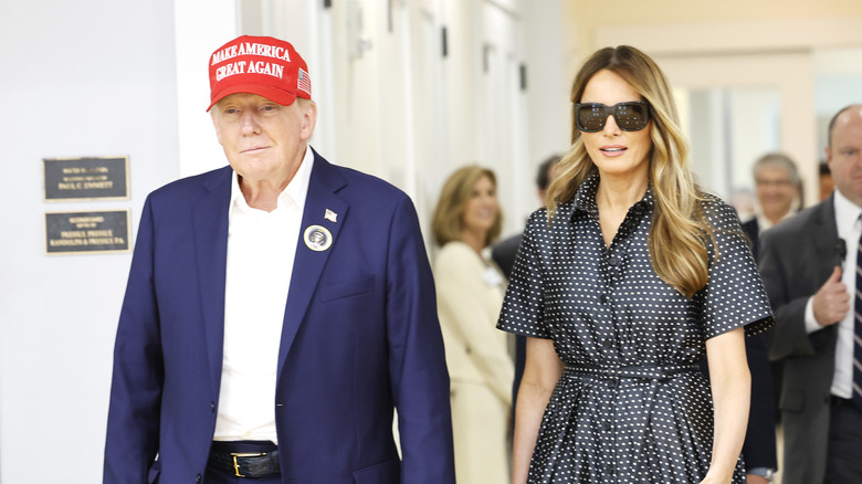 Donald Trump and Melania Trump walking while holding hands