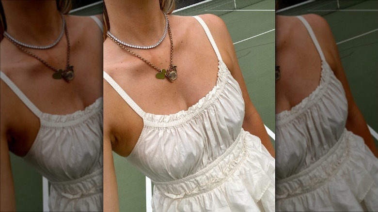 Woman wearing tennis necklace with charm necklace