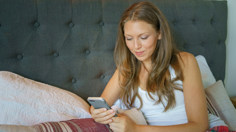 woman smirking while texting