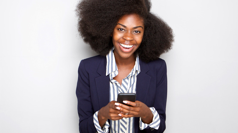 woman laughing and texting