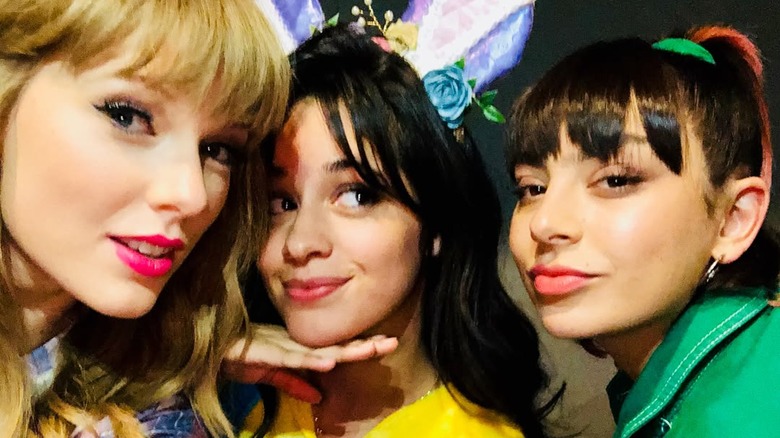 Taylor Swift taking a selfie with Camila Cabello and Charli XCX