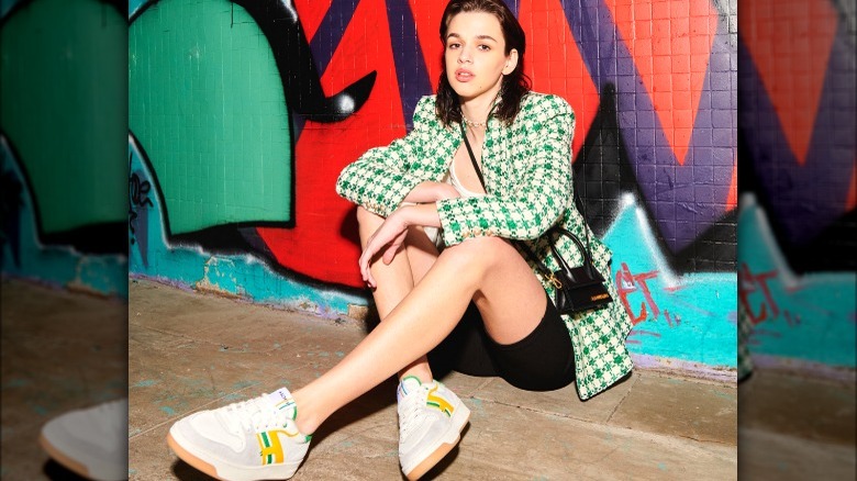 Model posing near graffiti wearing colorful sneakers