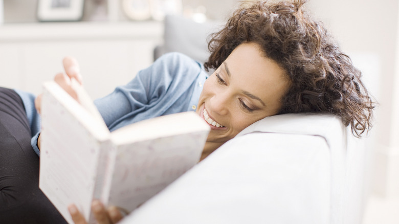 woman lounging and reading a book