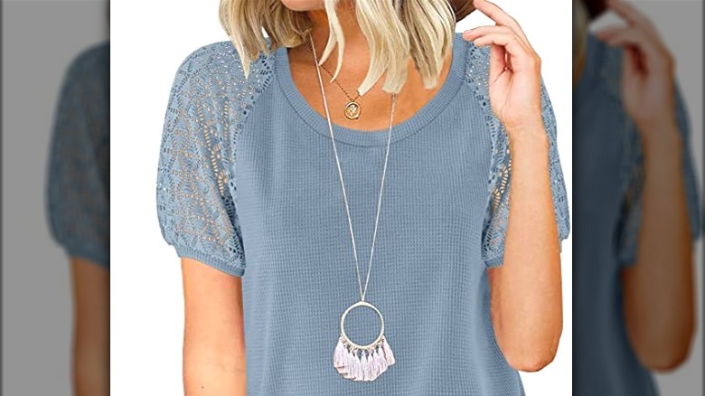 Model wearing blue t-shirt with lace sleeves