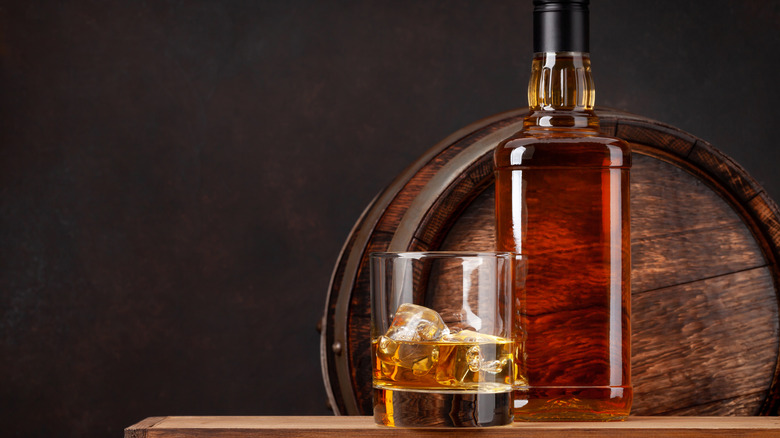 glass, bottle, and barrel of bourbon