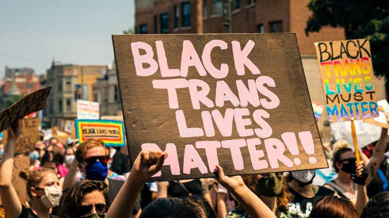 A protester holding a sign saying "Black Trans Lives Matter!!"