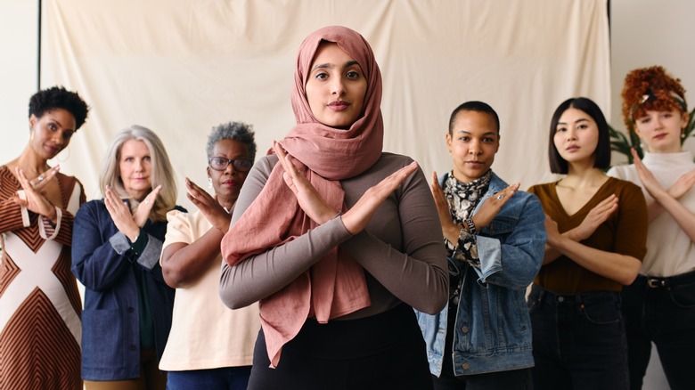 women doing "Break the Bias" gesture