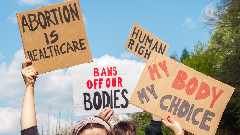 pro abortion protestors holding up signs