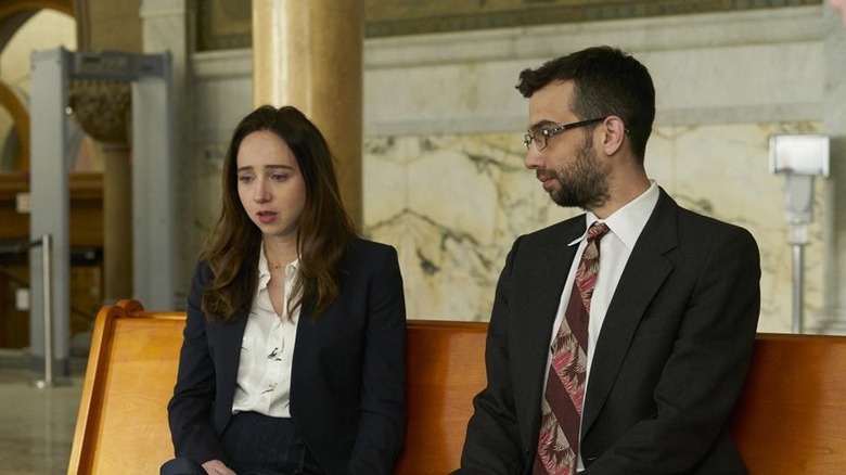 Clara and John sad in jackets on bench