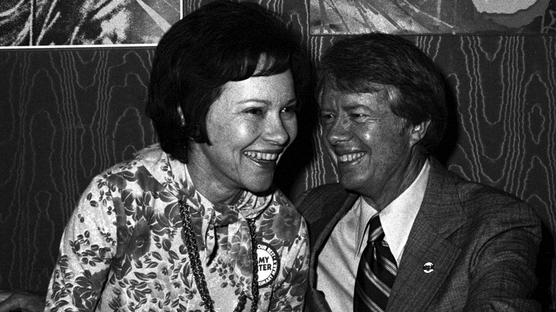 Rosalynn and Jimmy Carter sitting leaning in close to each other and smiling