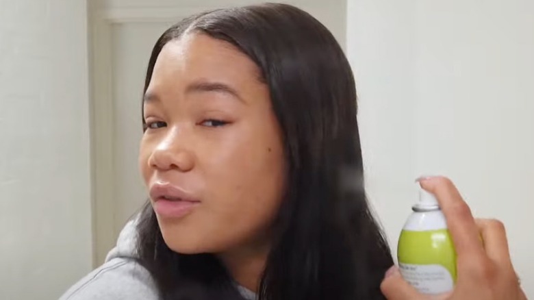 Storm Reid applying hair product