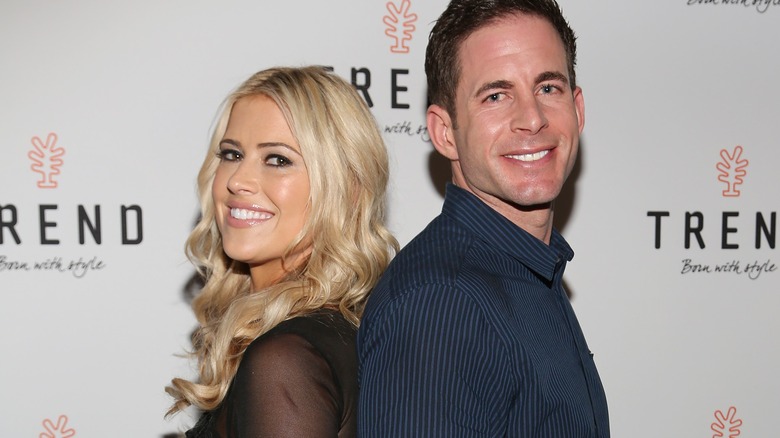 Christina Hall and Tarek El Moussa stand back to back