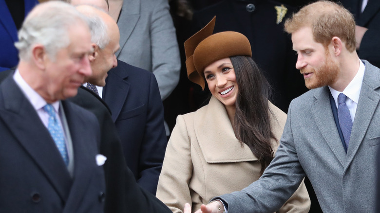 King Charles, Meghan Markle, and Prince Harry greeting people