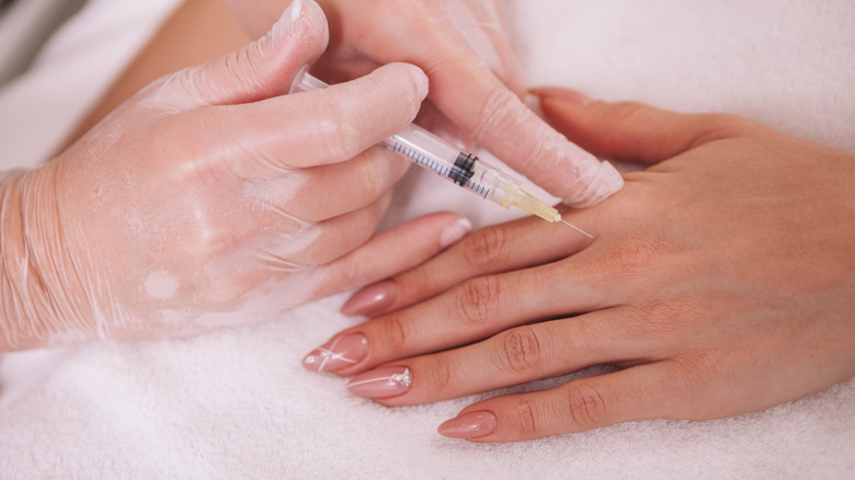 Beautician injecting hyaluronic acid