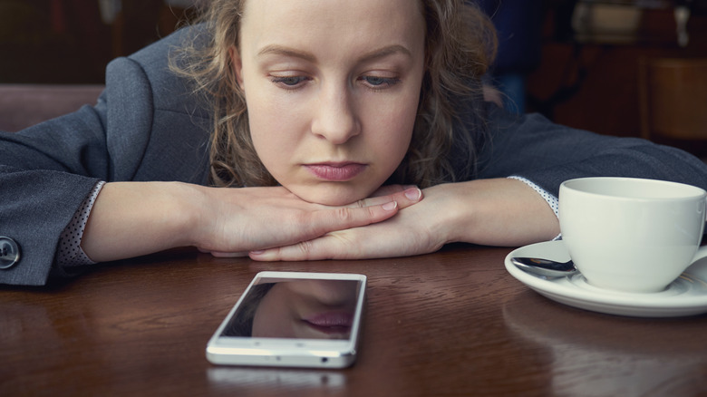 A woman staring at her cell phone