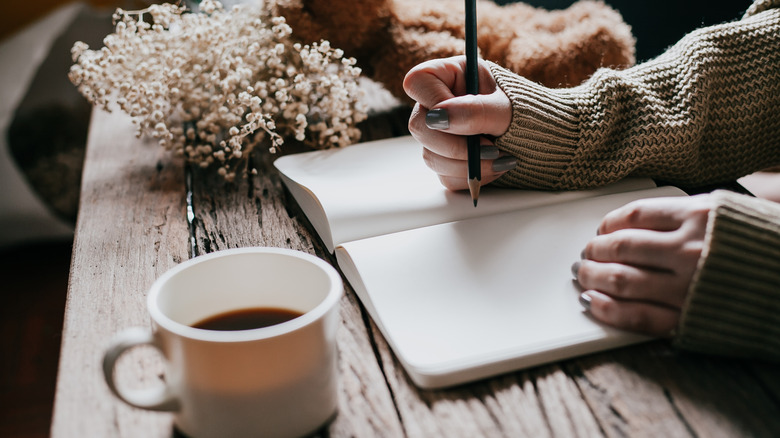 A woman writing in a journal 