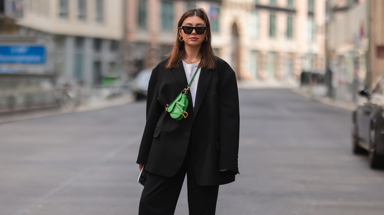 woman wearing green saddle bag