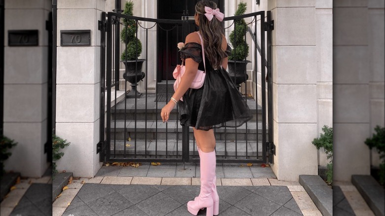 Woman in black dress and pink accessories