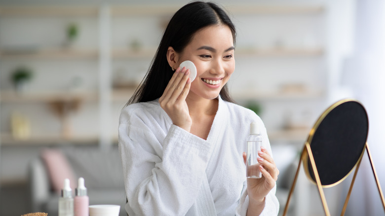 Woman applying toner to face