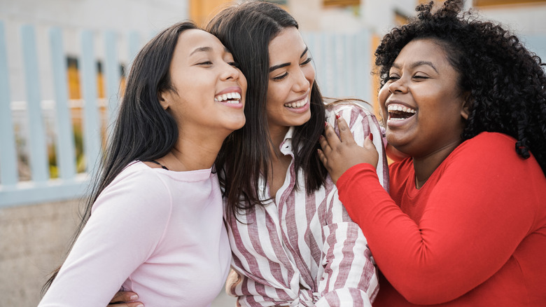 Three women embracing and smiling 