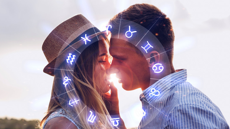 A man and woman about to kiss behind the zodiac wheel 