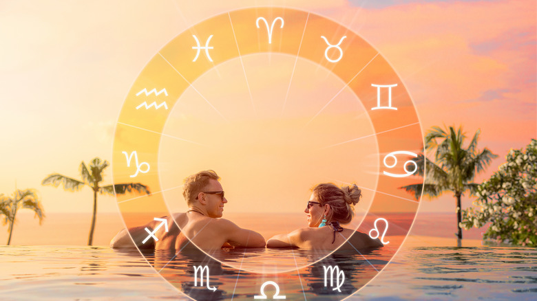 A man and woman in an infinity pool behind zodiac wheel 