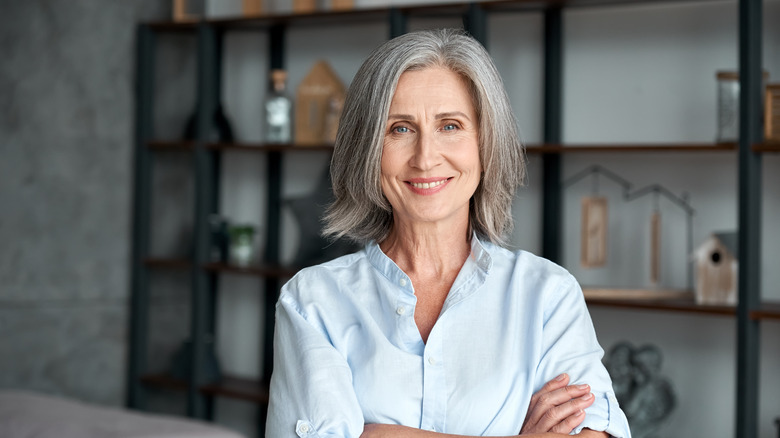 A woman standing proudly in a studio smiling 