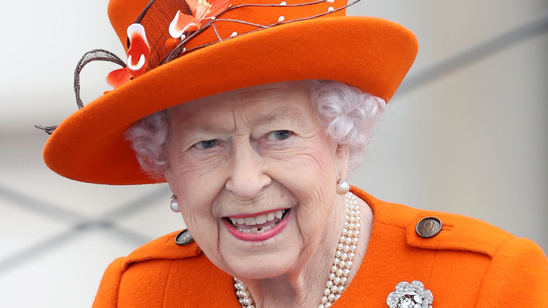 The queen wearing orange hat