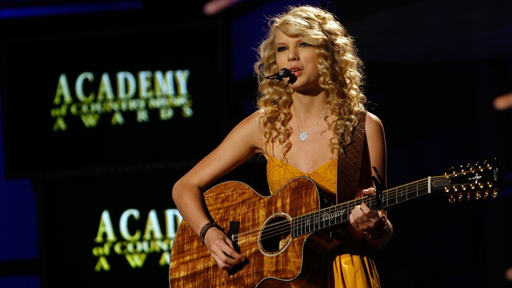Taylor Swift performing and playing guitar