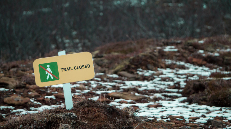 Hiking trail with a sign showing it is closed