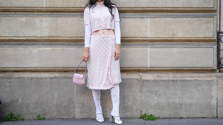 Pink outfit with a midi skirt, tights, and heels