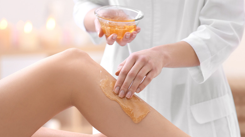Sugar wax being applied to woman's leg