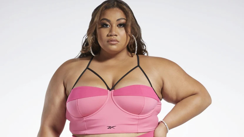 Woman in pink Reebok X Cardi B bralette