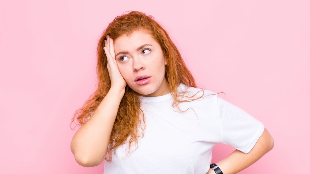 a woman with red hair looking stressed