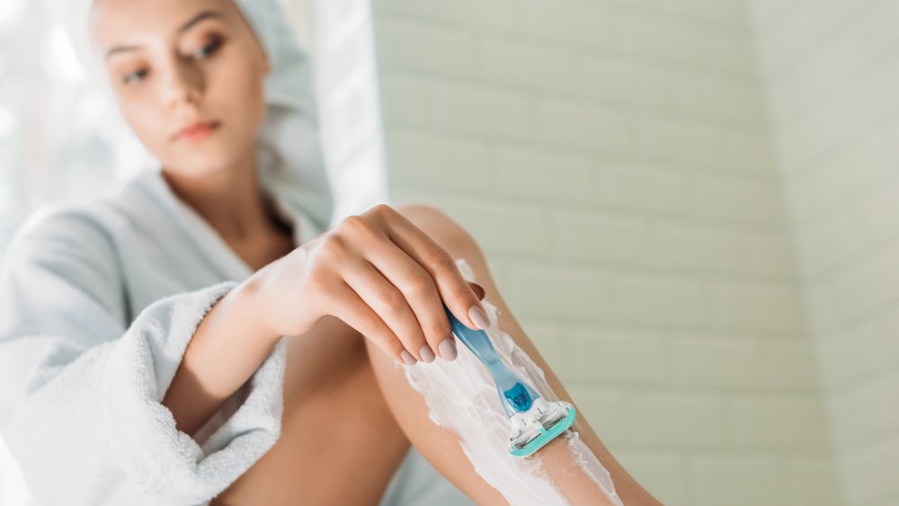 a woman shaving her legs