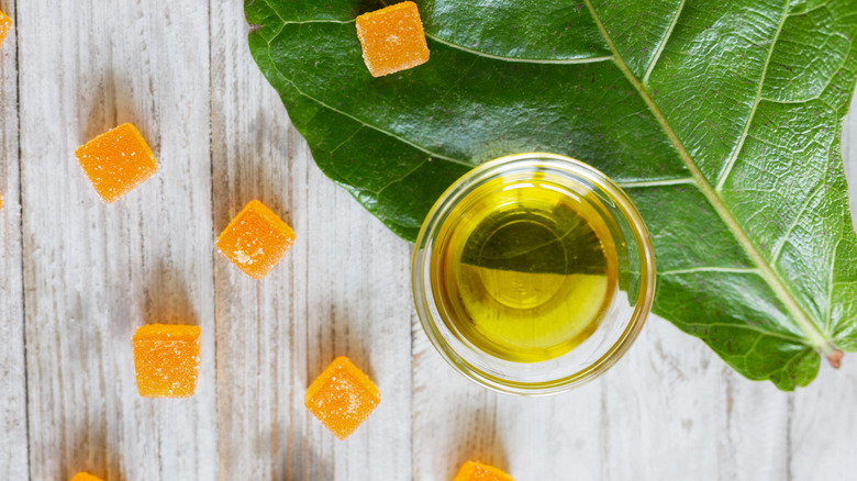 CBD gummies next to a bowl of CBD and a leaf