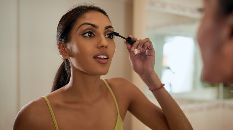 Woman applying mascara