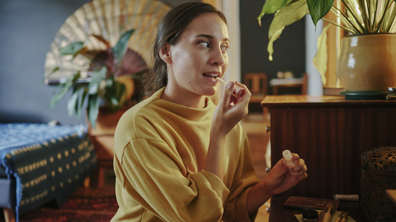 Woman applying lip gloss