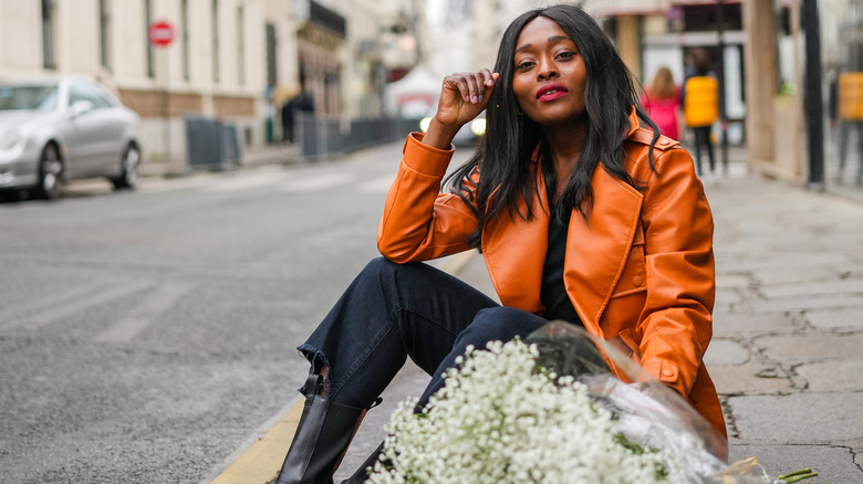 Woman in orange coat with flowers