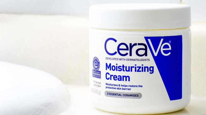 A tub of CeraVe moisturizing cream by the bathtub 