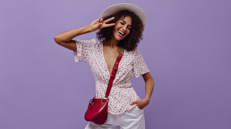 Smiling model wearing a red crossbody bag