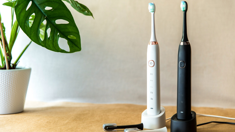 Two electric toothbrushes on counter