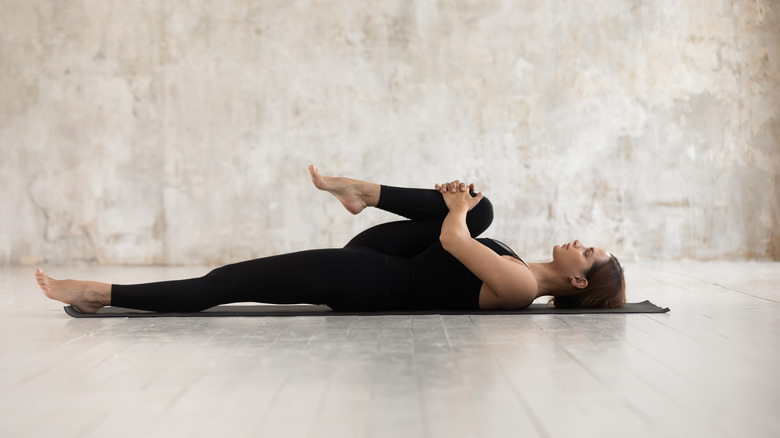 woman stretching her hamstrings on yoga mat