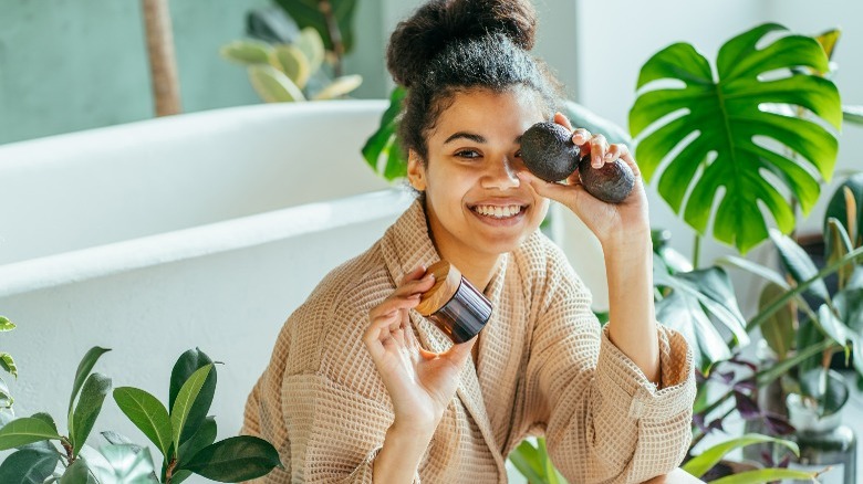 woman in bathrobe with avocados 