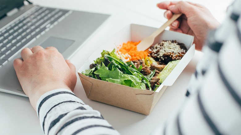 Woman eating at desk